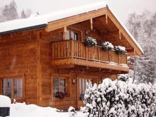 ein Blockhaus mit Balkon im Schnee in der Unterkunft Nettes Ferienhaus in Gaisbichl mit Terrasse und Garten in Niedernsill