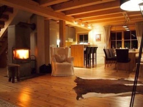 a living room with a fireplace and a dining room at Nettes Ferienhaus in Gaisbichl mit Terrasse und Garten in Niedernsill