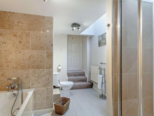 a bathroom with a shower and a toilet and a tub at 3 bed in Okehampton 49513 in Sampford Courtenay
