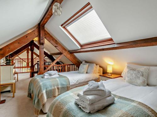 3 bed in Okehampton 49513 في Sampford Courtenay: سريرين في غرفة علوية مع منور