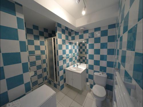 La salle de bains est pourvue de carrelage bleu et blanc. dans l'établissement Sainte-Marine, Appartement cosy rez-de-jardin à 150m de la plage, à Combrit