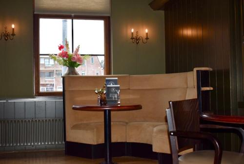a waiting room with a table and a couch at Hotel Restaurant 't Ronde Loegh in Winschoten