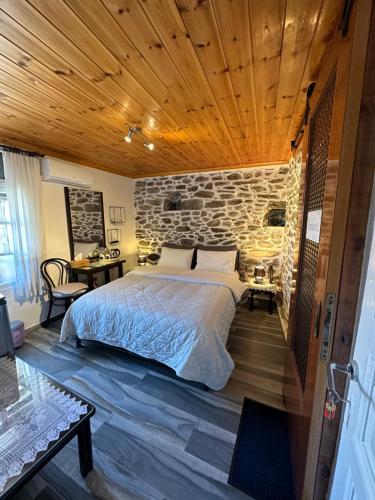 a bedroom with a bed and a stone wall at Old Town Traditional Residence in Kavala