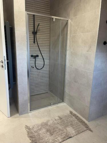 a shower with a glass door in a bathroom at Hotello Apartmanház és Panzió in Zalaegerszeg