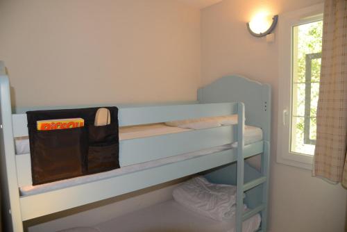 - un lit superposé avec un sac au-dessus dans l'établissement Maison avec 3 chambres et piscine proche de la plage, à Soulac-sur-Mer