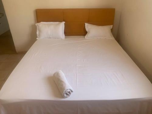 una cama blanca con una toalla puesta en Melia's hotel en Sali Nianiaral