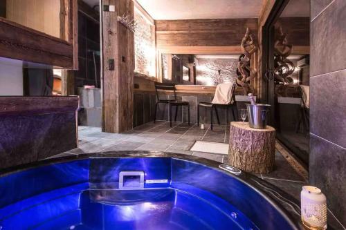 una gran bañera azul en una habitación con bar en K'banalours, en Sallanches