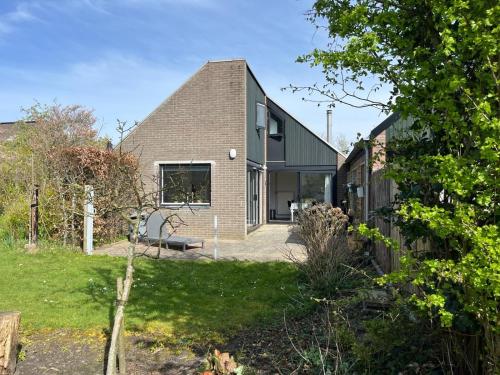 a brick house with a large window at Vakantiehuis Buitenplaats Schouwen in Burgh Haamstede