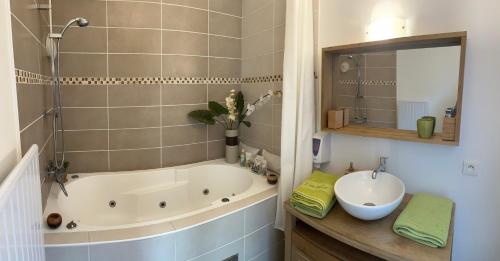a bathroom with a tub and a sink at LE FAUBOURG SAINT MARTIN in Senlis