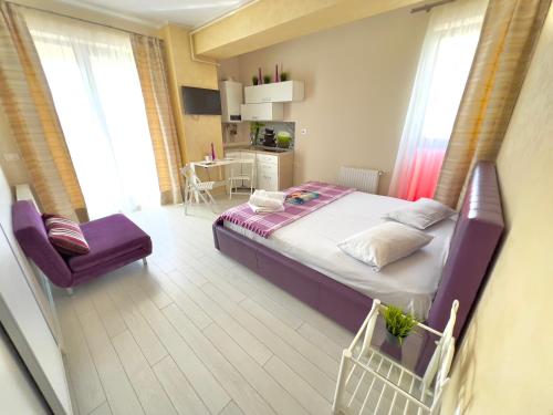 ein Schlafzimmer mit einem Bett und einem Stuhl darin in der Unterkunft BLUEMARINA SUMMERLAND SEA VIEW STUDIOS in Mamaia