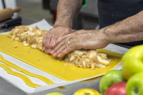 a person with their hands on a cutting board at Helmhotel in San Candido
