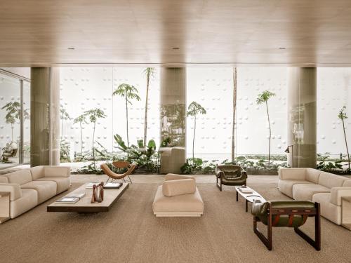 a large living room with white furniture and large windows at Pulso Hotel Faria Lima in Sao Paulo