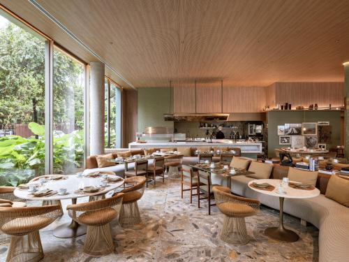 um restaurante com mesas e cadeiras e uma cozinha em Pulso Hotel Faria Lima em São Paulo