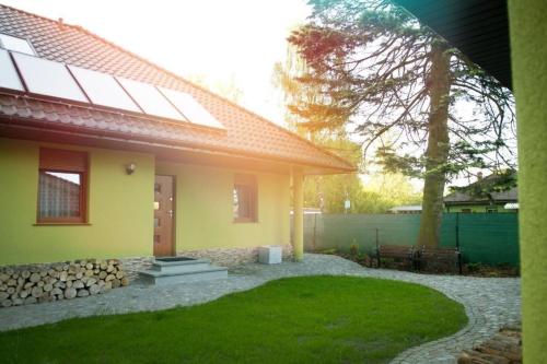 ein Haus mit einem grünen Garten mit Rasen in der Unterkunft Wohnung in Zieleniewo mit Garten und Grill in Zieleniewo