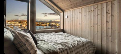 a bedroom with a bed and a large window at Cottage with a wiew in Sommarøy