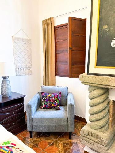 a blue chair with a pillow in a room at Casa Balam Bed & Breakfast Boutique in Ciudad Vieja