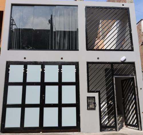 a house with four windows and a door at Casa sabina aeropuerto plus 1 in Lima