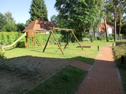 een speeltuin met een schommel in een park bij Ferienwohnung für 3 Personen in Bad Saarow, Berlin - b43675 in Bad Saarow