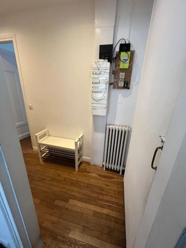 un couloir avec une chambre avec un radiateur et une table dans l'établissement Calm apartment in great location, à Paris
