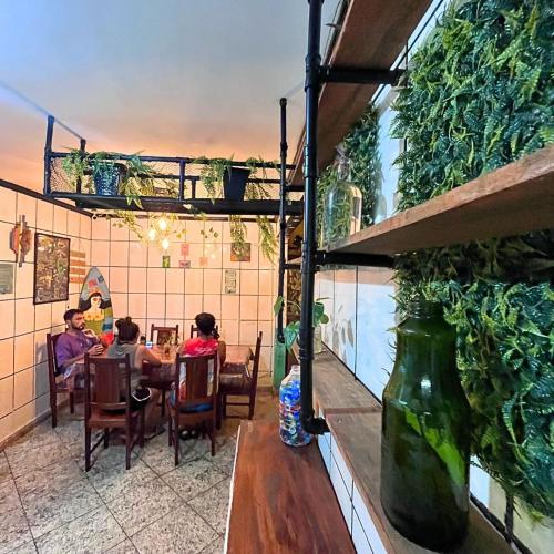 two people sitting at a table in a restaurant at Chamos Hostel Cultural in Arraial do Cabo