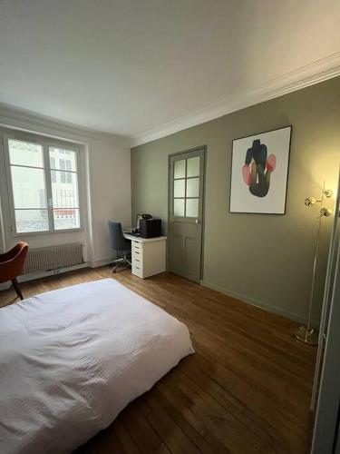 une chambre avec un lit blanc et un bureau dans l'établissement Calm apartment in great location, à Paris