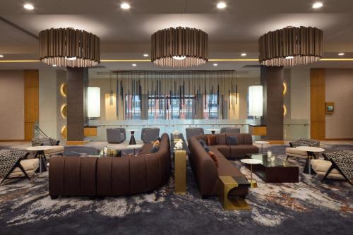 a hotel lobby with couches and tables and chandeliers at The Hotel at Arundel Preserve in Hanover