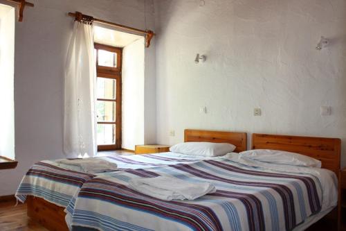una camera con due letti e una finestra di Sotos pension a Skopelos Town