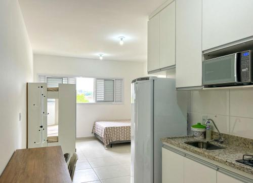una cucina con frigorifero e una camera con letto di Apto com otima localizacao - Cachoeira Paulista SP a Cachoeira Paulista