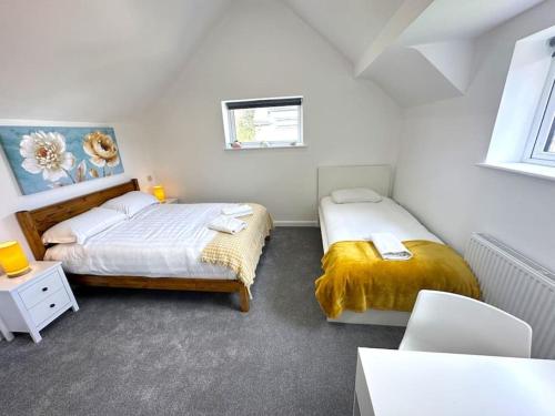 a bedroom with two beds and a table and chairs at Elegant 2-Bed in Central Headington-Modern New Built Retreat- Wi-Fi, Netflix, Top Location in Oxford