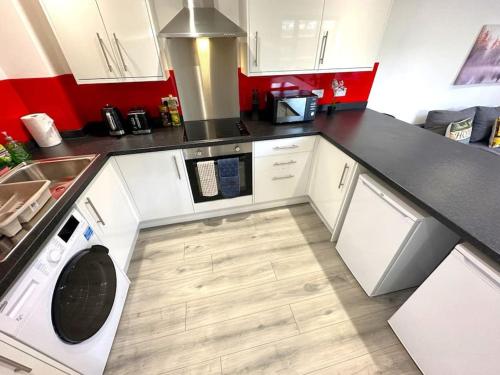 a kitchen with a washing machine in the middle at Elegant 2-Bed in Central Headington-Modern New Built Retreat- Wi-Fi, Netflix, Top Location in Oxford