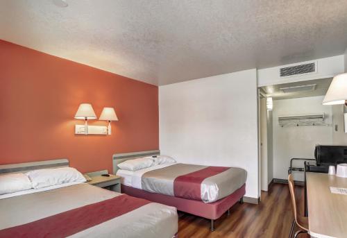a hotel room with two beds with orange walls at Motel 6-Medford, OR in Medford