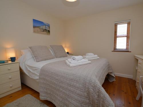 a bedroom with a bed with two towels on it at 3 bed property in Bude HAPPY in Poughill