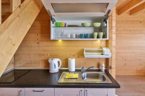 a kitchen with a sink in a tiny house at Wohnung in Paprotno mit Grill, Garten und Terrasse in Gąski