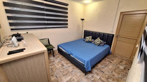 een slaapkamer met een bed en een bureau met een telefoon bij Appartement neuf au cœur de Quatre Bornes in Quatre Bornes