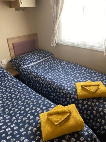 ファーンダウンにあるnarcissusの黄色いタオルが付いた部屋のベッド2台