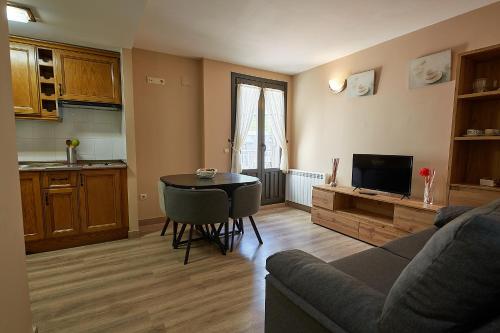 a living room with a couch and a table and a kitchen at Santa Cruz in Broto