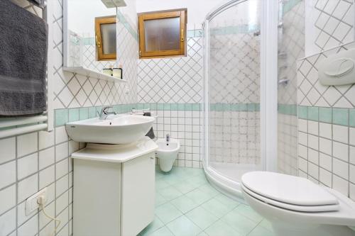 La salle de bains est pourvue d'un lavabo, de toilettes et d'une douche. dans l'établissement A Casa di Anna Maria, à Brenzone