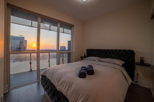 a bedroom with a bed with two pairs of shoes on it at Luxury Condo w/Mesmerizing Sunset Views & FREE Parking in Toronto