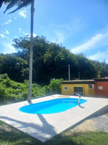 una persona parada frente a una piscina en Canto Rei Cabanas Rosa Sul, en Imbituba