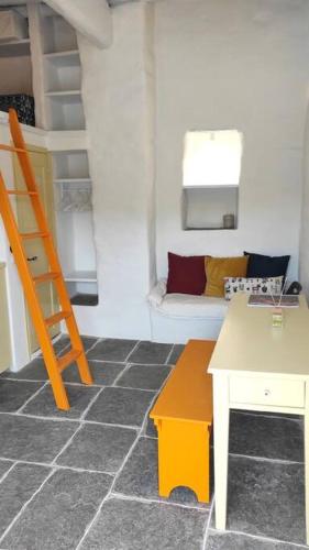 a living room with a ladder and a couch at Hidden Gem - Sifnos, Kastro. in Kástron