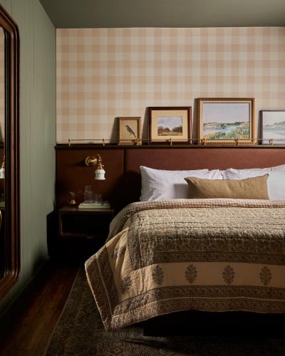 1 dormitorio con 1 cama y algunas fotos en la pared en The June Motel, Beaver Valley, 
