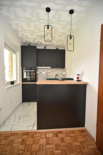 a kitchen with black cabinets and a counter top at Sobe Zimmer Rooms 2 in Bileća