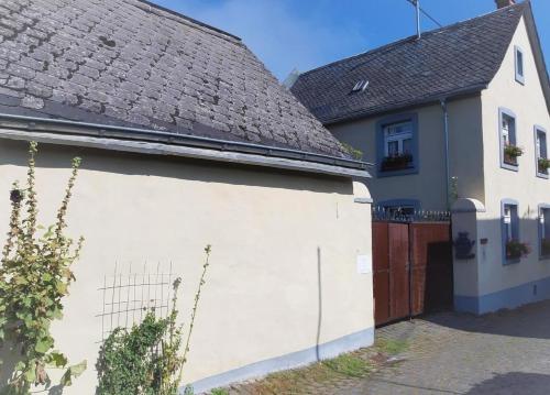 uma casa branca com um telhado castanho em Wellness-Ferienhaus mit Privat-Spa em Gappenach