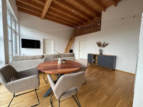 uma sala de estar com uma mesa e cadeiras e um sofá em Stilvolle Ferienwohnung in ruhiger Lage em Willingen