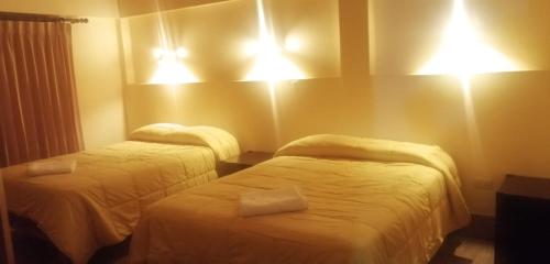 a hotel room with two beds and lights on the wall at Terra Encantada in Maranura