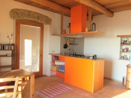 uma cozinha com uma ilha laranja num quarto em Schönes Appartement in Tortorella mit Terrasse und Garten em Tortorella