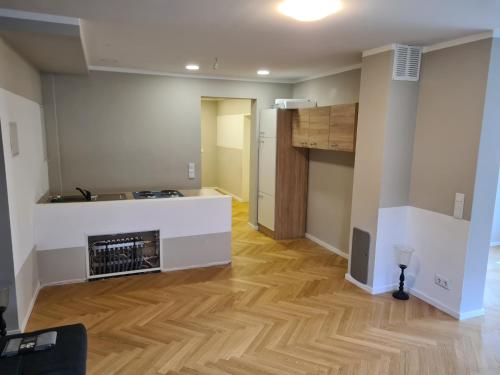 ein leeres Wohnzimmer mit einer Küche und Holzböden in der Unterkunft GardenLoft no1 in Wien