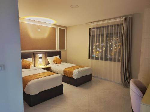 a hotel room with two beds and a window at Rakan ApartHotel and Luxury Rooms in Wadi Musa