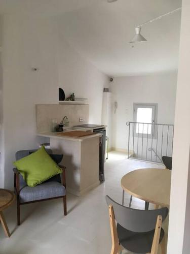 un salon avec une table et des chaises et une cuisine dans l'établissement Au cœur d'Uzès la Terrasse d’Austerlitz, à Uzès