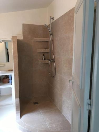 une salle de bain avec une douche avec une porte vitrée dans l'établissement Au cœur d'Uzès la Terrasse d’Austerlitz, à Uzès